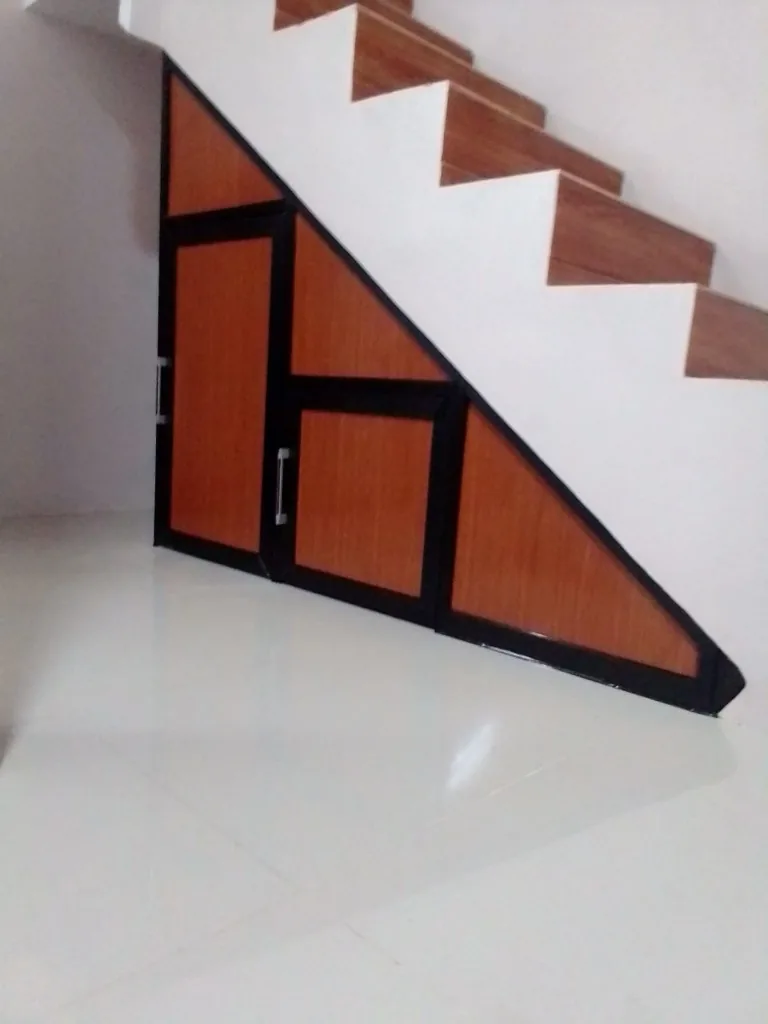 Kabinet aluminium custom mengikuti bentuk bawah tangga